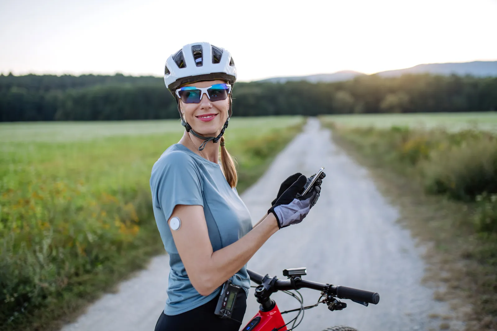 A woman on a bike wearing a glucose sensor and insulin pump