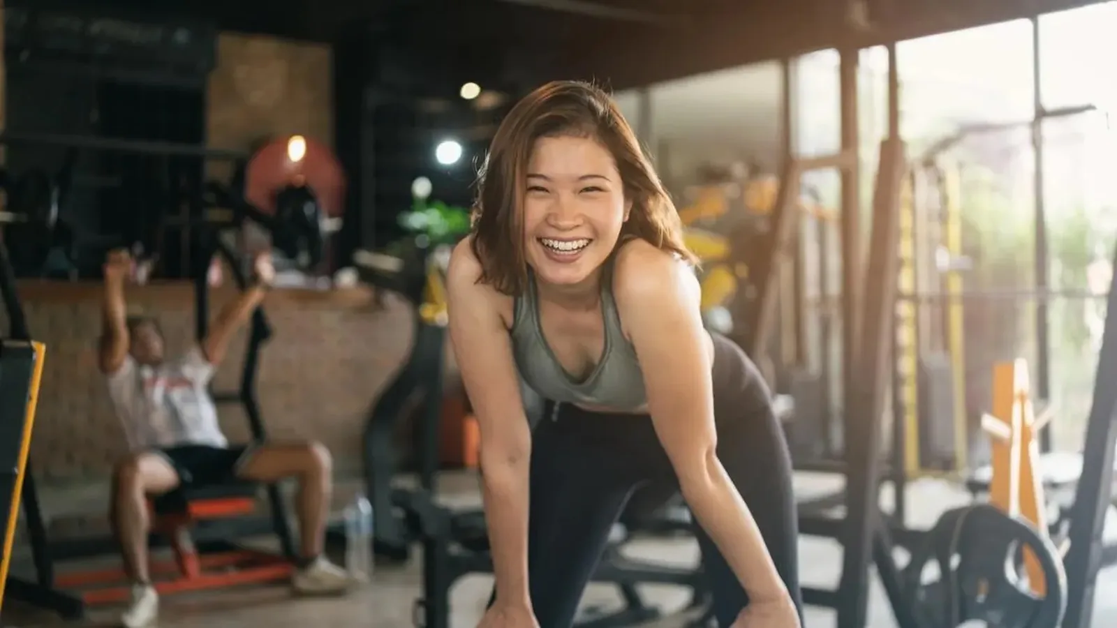 Someone smiling mid-session in a gym, pausing between sets